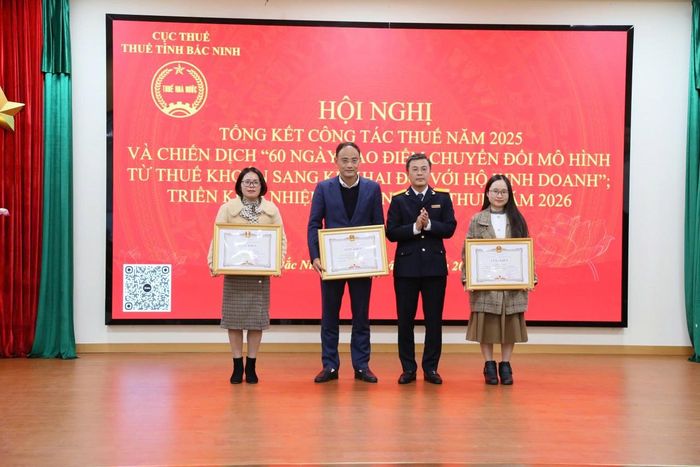 Phó Cục trưởng Cục Thuế Lê Long tặng giấy khen của Cục Thuế cho các cá nhân có thành tích xuất sắc. Ảnh: Tùng Sơn