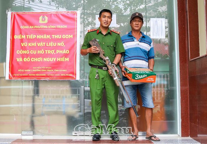 Công an phường Vĩnh Trạch tiếp nhận súng do người dân tự nguyện giao nộp. (Ảnh: Quốc Quang)
