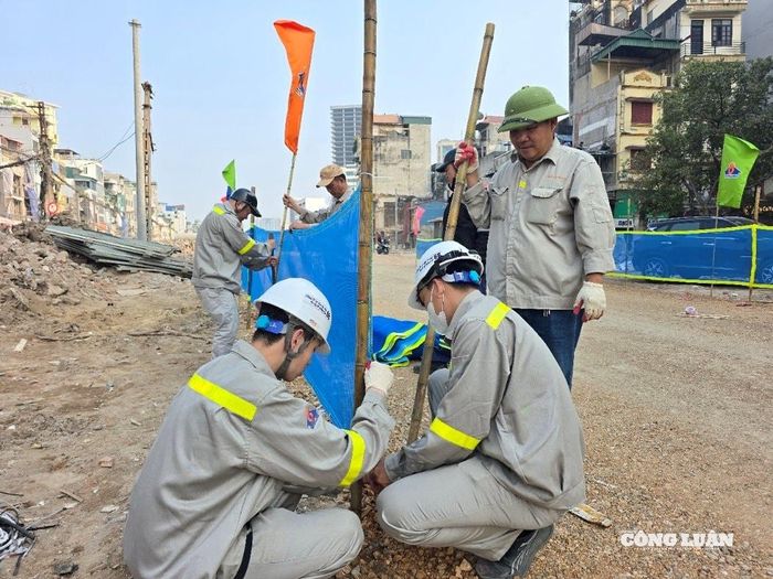 Công nhân đang căng biển cảnh báo dọc hai bên tuyến đường đảm bảo an toàn cho người lưu thông