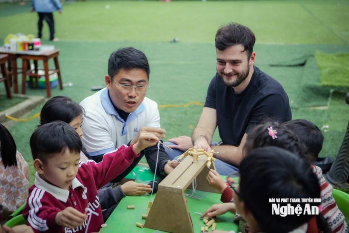 Anh Đồng Quang Vinh (đeo kính) trong một chương trình hướng dẫn thiếu nhi làm đồ chơi thủ công. Ảnh: NVCC