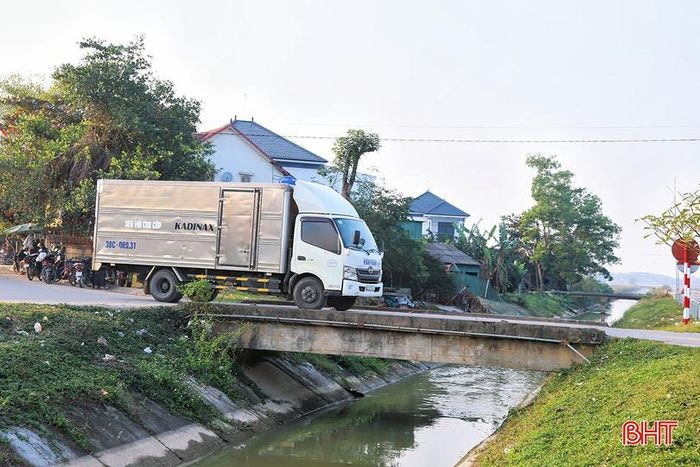 Theo người dân địa phương, cây cầu được xây dựng khoảng 20 năm trước và từng có lan can bảo vệ. Tuy nhiên, do mặt cầu hẹp, khúc cua gắt, các phương tiện trọng tải lớn thường xuyên lưu thông đã va quệt làm lan can hư hỏng, gãy đổ. Đến nay, toàn bộ lan can không còn.