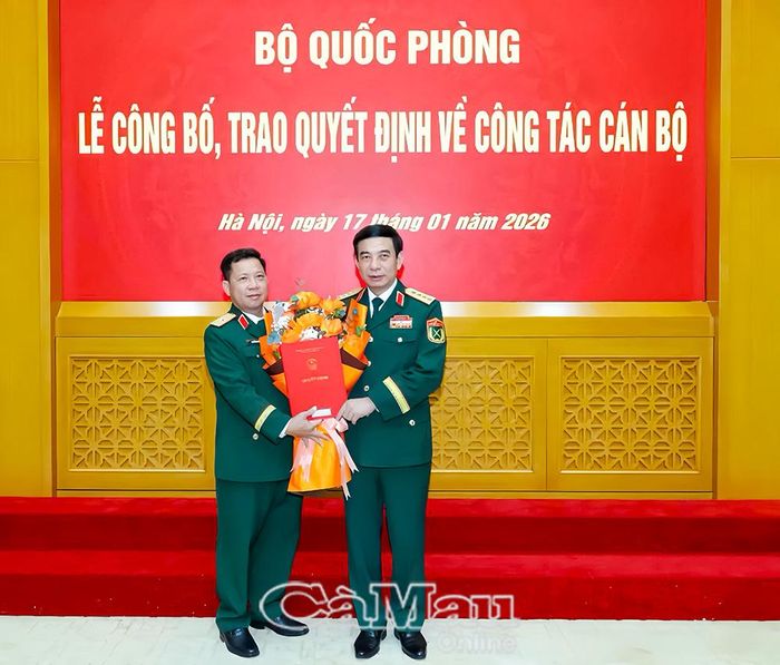 Đại tướng Phan Văn Giang, Ủy viên Bộ Chính trị, Phó Bí thư Quân ủy Trung ương, Bộ trưởng Bộ Quốc phòng trao quyết định và tặng hoa chúc mừng Thiếu tướng Nguyễn Văn Hùng.