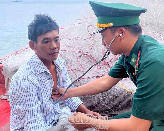 Cán bộ Quân y Đồn Biên phòng Hòn Khoai thăm khám sức khỏe cho thuyền viên Nguyễn Văn Sơn trực tiếp trên tàu cá.