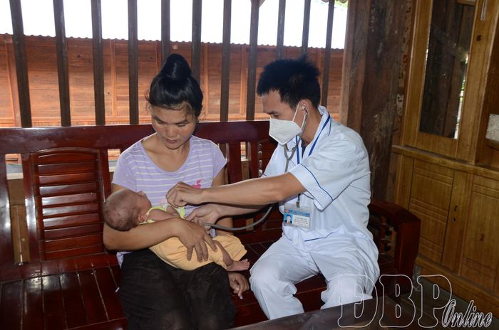 Cán bộ y tế xã Na Sang kiểm tra sức khỏe cho trẻ sơ sinh tại nhà.