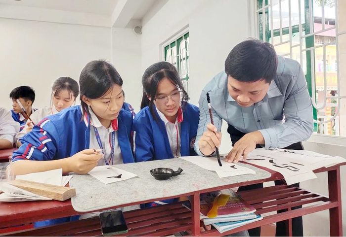  Anh Lê Thành Văn truyền dạy viết thư pháp tại Câu lạc bộ Thư pháp Hán Nôm Trường Nguyễn Bỉnh Khiêm (phường Nếnh). 