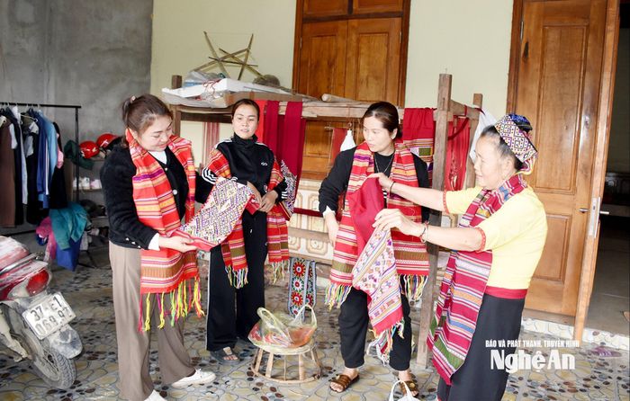 Chị em phụ nữ Thái mua khăn, váy, áo thổ cẩm chuẩn bị đón Tết. Ảnh: Công Kiên