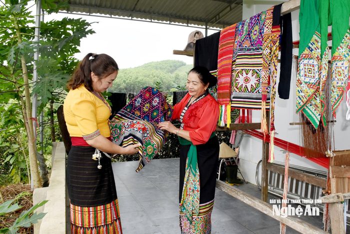 Bà Vi Thị Liên (phải) ở bản Tân Ngọc, xã Sơn Lâm chuẩn bị các sản phẩm dệt thổ cẩm. Ảnh: Công Kiên