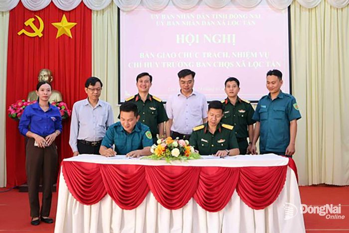 Đại diện Phòng thủ Khu vực 4 - Bình Long cùng lãnh đạo xã chứng kiến lễ kí kết bàn giao. Ảnh: Thúy Anh
