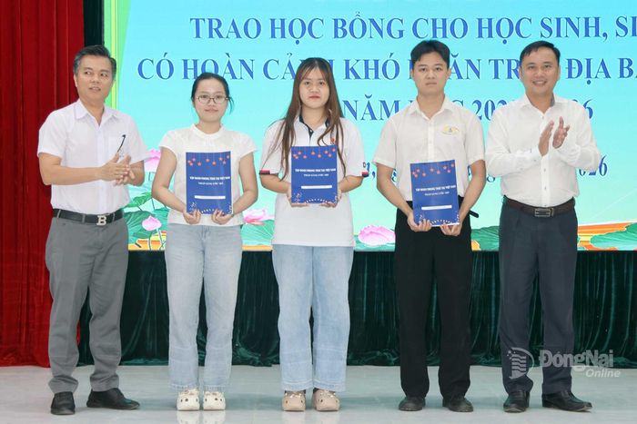 Lãnh đạo xã Trị An và đại diện Tập đoàn Phong Thái trao học bổng cho các em học sinh, sinh viên. Ảnh: Quang Huy
