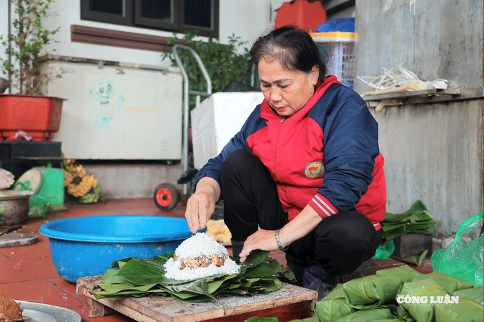 Những đôi tay thoăn thoắt chỉ mất khoảng 20-30 giây để hoàn thiện một chiếc bánh chưng vuông vức mà không cần khuôn.