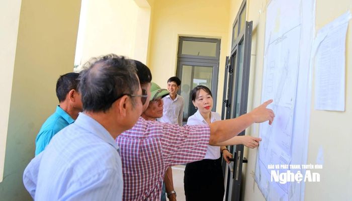 Cán bộ xã Hưng Nguyên Nam giải thích quy hoạch khu tái định cư cho người dân. Ảnh: CSCC