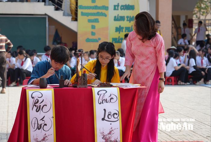 Học sinh Trường THCS Lê Mao tìm hiểu về nghệ thuật viết thư pháp. Ảnh: Mỹ Hà