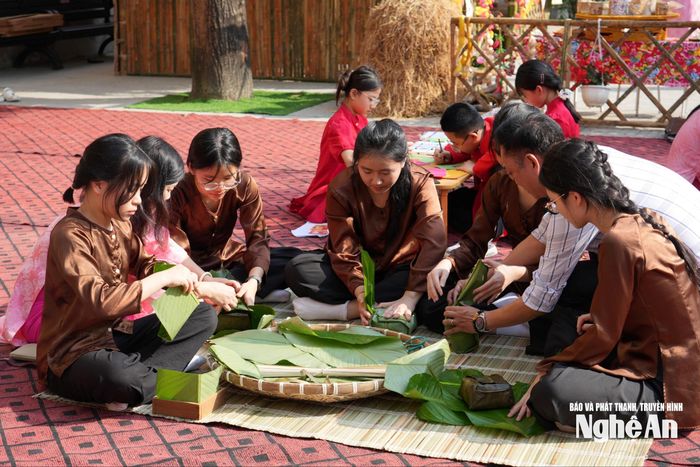 Các em học sinh trải nghiệm gói bánh chưng. Ảnh: Mỹ Hà