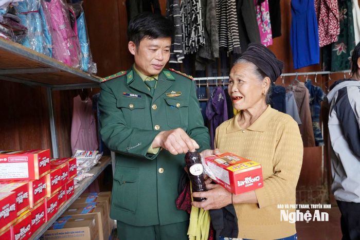 Cán bộ Trạm Biên phòng Khe Khặng trao quà Tết cho bà Vi Thị Kỷ. Ảnh: T.P