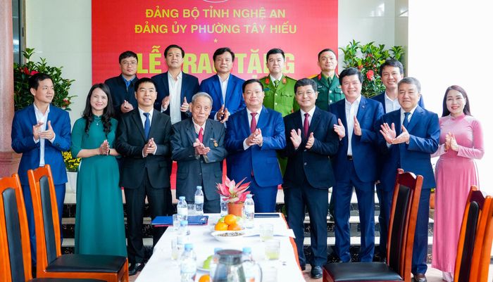 Các đồng chí lãnh đạo tỉnh và phường Tây Hiếu chụp ảnh chúc mừng đảng viên Đặng Ích Chí. Ảnh: Phạm Bằng
