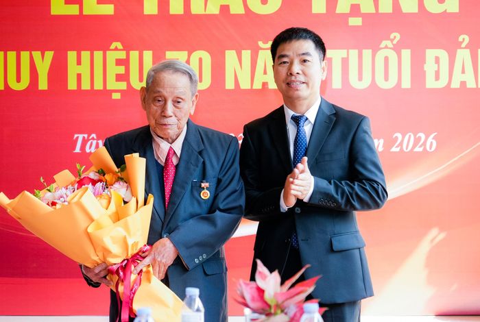 Lãnh đạo phường Tây Hiếu tặng hoa chúc mừng đảng viên Đặng Ích Chí. Ảnh: Phạm Bằng