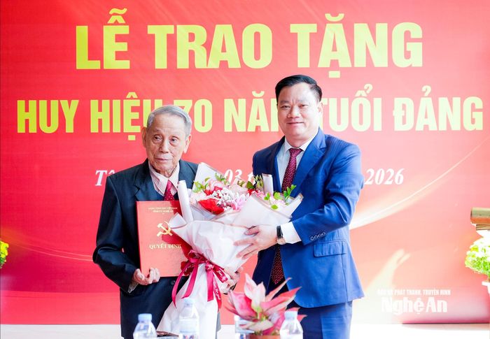 Đồng chí Nguyễn Khắc Thận - Ủy viên Ban Chấp hành Trung ương Đảng, Bí thư Tỉnh ủy trao quyết định và tặng hoa chúc mừng đảng viên Đặng Ích Chí. Ảnh: Phạm Bằng