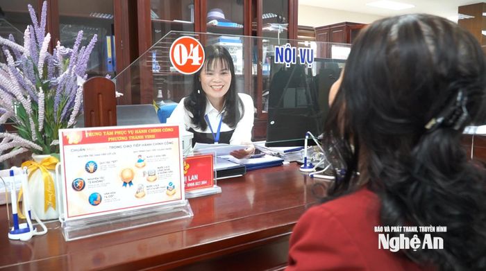 Cán bộ Trung tâm Phục vụ hành chính công phường Thành Vinh vui vẻ hướng dẫn người dân nộp hồ sơ trực tuyến. Ảnh: Hoàng Việt Anh