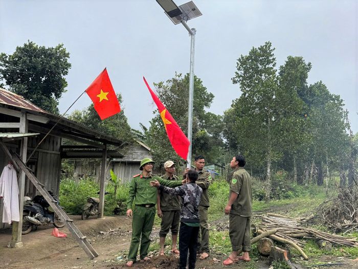 Các lực lượng lắp đặt 5 đèn năng lượng mặt trời và ra mắt mô hình "Ánh sáng an ninh vùng biên" tại khu dân cư. Ảnh: PÊ LÊ