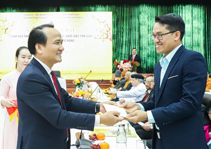 Phó Bí thư Thường trực Thành ủy Nguyễn Đình Vĩnh (trái) tặng quà chúc Tết chức sắc, chức việc. Ảnh: NGỌC PHÚ