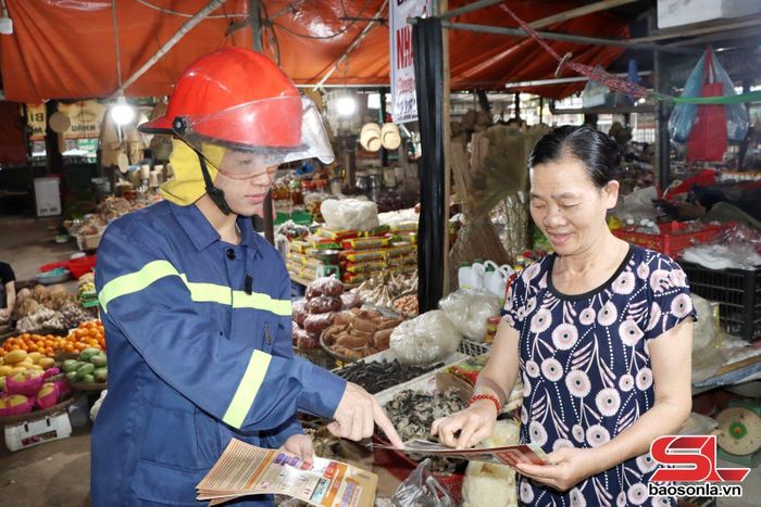 Cán bộ Đội chữa cháy và CNCH khu vực VI tuyên truyền PCCC cho hộ kinh doanh tại Chợ trung tâm Sông Mã.