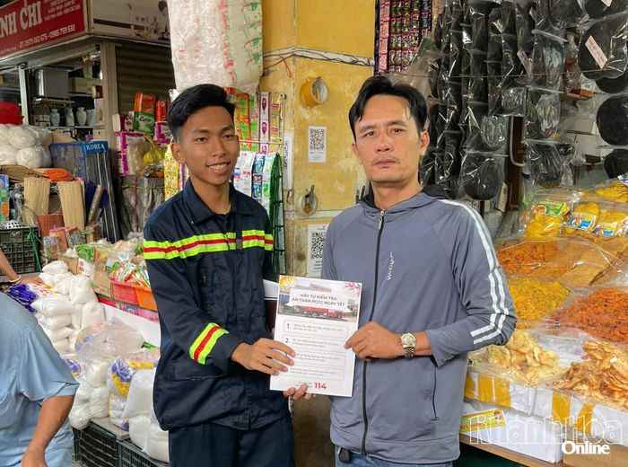 Chiến sĩ chữa cháy phát tờ rơi tuyên truyền cho các tiểu thương.