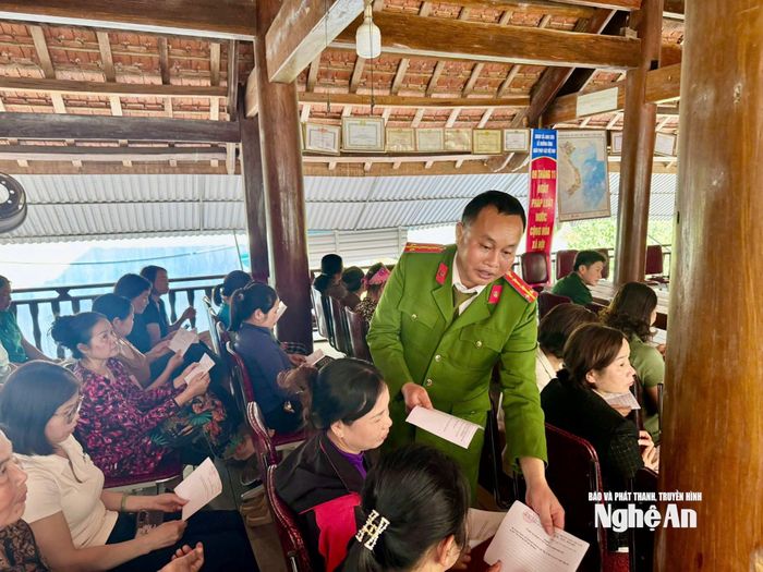 Công an xã Anh Sơn phát phiếu lấy ý kiến nhân dân tại diễn đàn. Ảnh: P.V