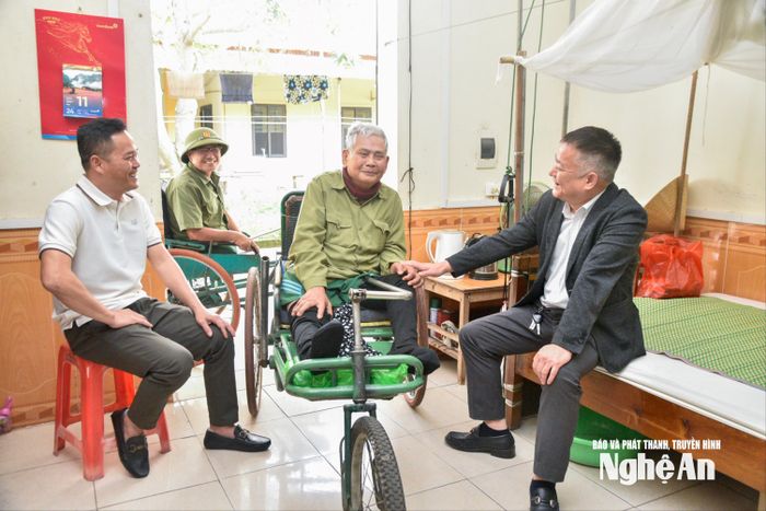 Cán bộ Trung tâm trò chuyện với thương binh Ngô Xuân Kiện. Ảnh: Minh Quân