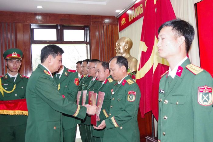 Đại tá Võ Văn Tuấn, Phó Bí thư Thường trực Đảng ủy Quân sự, Chính ủy Bộ Chỉ huy Quân sự thành phố trao quyết định cho các sĩ quan. Ảnh: MINH THY
