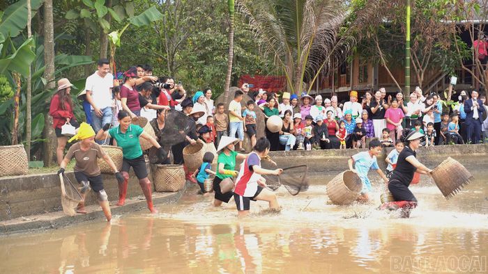 Ruộng vừa gặt xong, nước được tháo cạn, cá lộ mình trong lớp bùn non cũng là lúc tiếng cười của những người đi bắt cá rộn ràng vang lên giữa cánh đồng. (Trong ảnh: Đồng bào Mường tái hiện tập tục bắt cá ruộng - nguồn thực phẩm quan trọng sau mỗi vụ lúa. Đây không chỉ là sinh kế mà còn là nét sinh hoạt cộng đồng gắn kết gia đình, bản xóm).