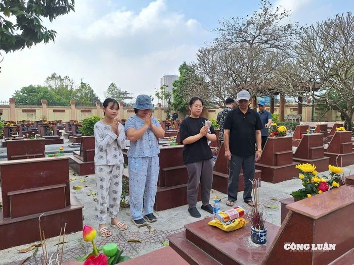 Có những gia đình gồm nhiều thế hệ cùng giữ thói quen đến nghĩa trang, thăm phần mộ của gia đình để mời người thân về ăn Tết như để bắt đầu một năm mới. Ảnh: HK