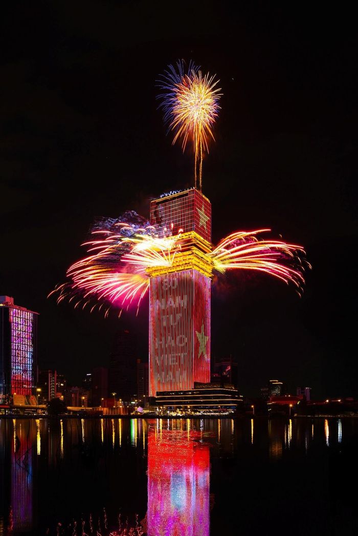 Màn pháo hoa bùng nổ từ đỉnh tháp Saigon Marina IFC, phản chiếu xuống sông Sài Gòn, tạo nên đại cảnh ánh sáng ấn tượng trên đường chân trời thành phố.