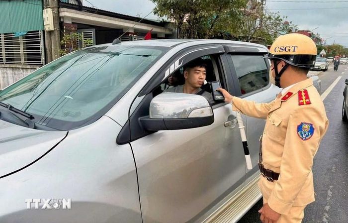 Lực lượng cảnh sát giao thông đo nồng độ cồn người tham gia giao thông trong những ngày nghỉ Tết.Ảnh: Công Tường/TTXVN