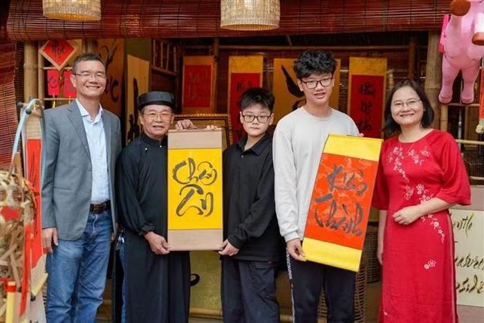 Một gia đình xin chữ đầu năm tại Không gian Hồ Văn, Di tích Quốc gia đặc biệt Văn Miếu – Quốc Tử Giám (Hà Nội) ngày mùng 2 Tết Bính Ngọ. Ảnh: Khánh Hoà/TTXVN