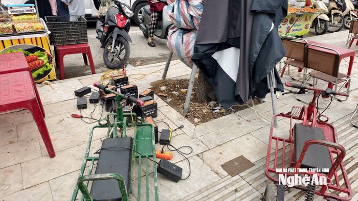 Ắc quy xe được sạc trên vỉa hè. Ảnh: Diệp Thanh