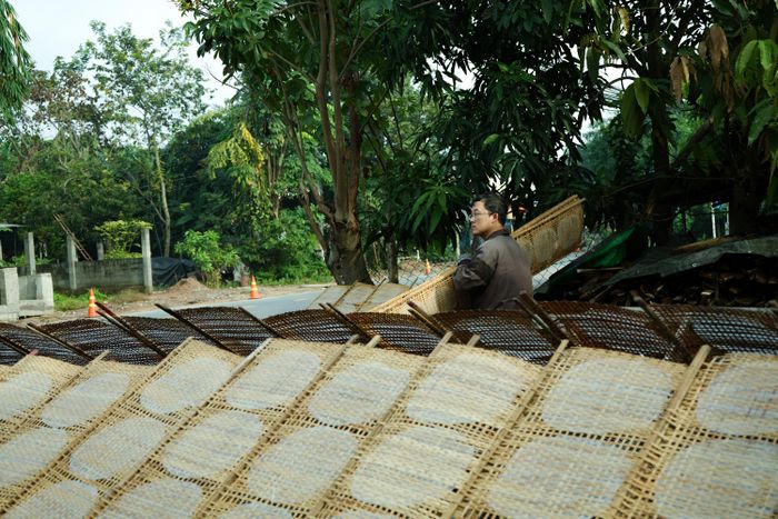  Chồng chị Châu sắp xếp ngay ngắn những chiếc liếp tre để bánh tráng hứng nắng đồng đều. 