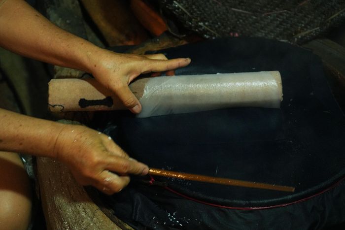  Khi một chiếc bánh chín, người thợ dùng một chiếc ống luồn để gỡ bánh khỏi tấm vải. 