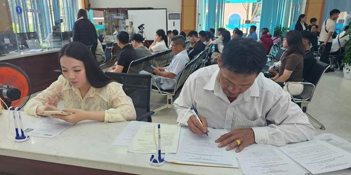 Người dân làm thủ tục tại Trung tâm PVHCC thành phố Huế trong sáng ngày đầu làm việc sau Tết. 