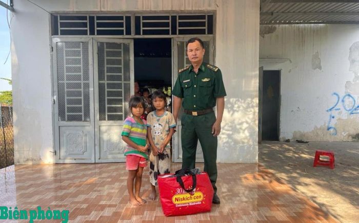 Trung tá Ngô Minh Đức tặng quà cho các em nhỏ có hoàn cảnh khó khăn. Ảnh: Hồng Ánh