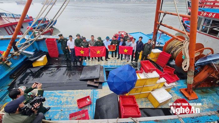 Ông Cao Minh Tú - Chủ tịch UBND phường Cửa Lò trao cờ cho đôi tàu của anh Trần Văn Lưu. Ảnh: Nguyễn Toàn