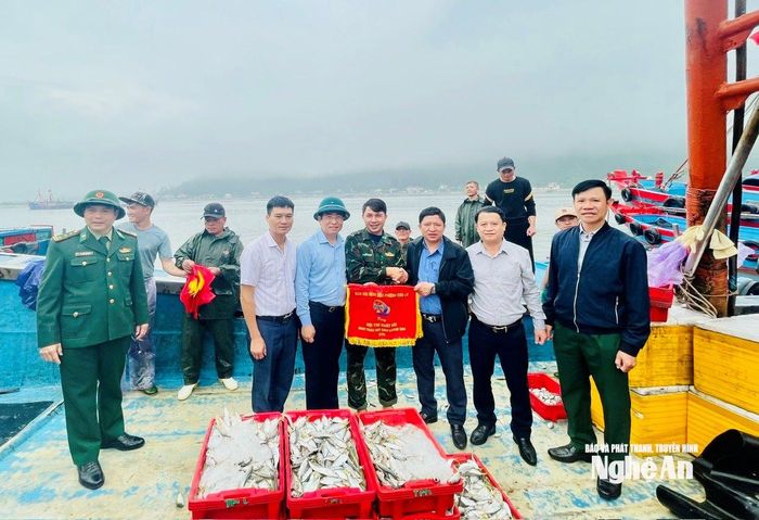 Ông Cao Minh Tú - Chủ tịch UBND phường Cửa Lò trao cờ cho đôi tàu của anh Trần Văn Lưu. Ảnh: Nguyễn Toàn