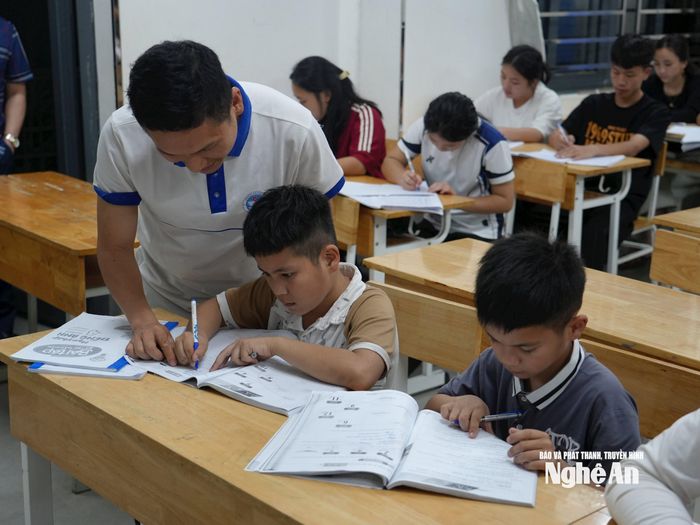 Trường THPT Kỳ Sơn hiện là 1 trong 2 trường trên toàn tỉnh thực hiện mô hình trường bán trú kiểu mới. Tuy nhiên, trên thực tế, hiện nay giáo viên của trường vẫn đang dạy học và hưởng các quyền lợi như các giáo viên ở trường bình thường. Để duy trì các lớp học buổi tối, 100% giáo viên trong trường tình nguyện dạy thêm, tăng ca miễn phí. Trong ảnh: Thầy giáo Nguyễn Văn Đạt cùng con đến lớp ôn thi với các anh chị khóa 12: Cả 2 vợ chồng chúng tôi đều dạy cùng trường và cùng ôn thi cho học sinh. Vì thế, chúng tôi sẽ đưa các con đến trường để vừa trông con, vừa có thể hoàn thành nhiệm vụ - thầy Đạt cho biết. Ảnh: Thành Chung