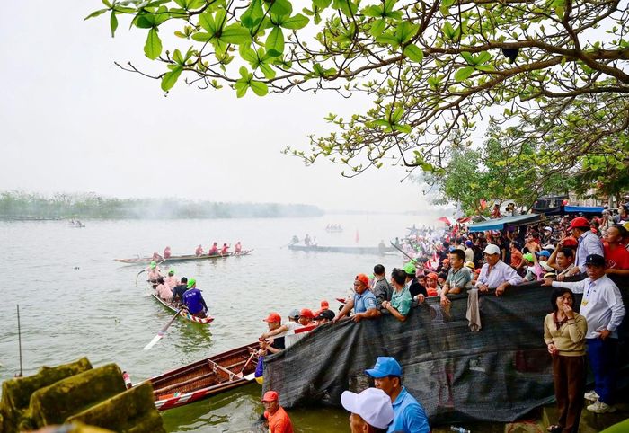 Từ sáng sớm, khu vực đình làng Triều Sơn Đông và đoạn sông Hương phía trước rộn ràng tiếng trống lệnh, tiếng hò reo cổ vũ. Không khí hội xuân vùng ven sông lan tỏa khắp xóm làng, thu hút đông đảo người dân địa phương và khách thập phương về dự hội. Ảnh: Hoàng Hải.