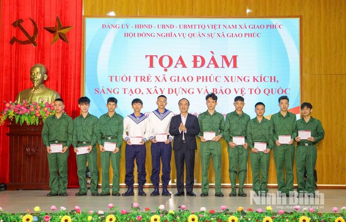 Lãnh đạo xã trao tặng sổ tiết kiệm cho các tân binh có hoàn cảnh khó khăn. Ảnh: Văn Huỳnh