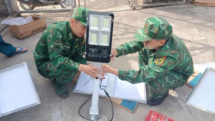Cán bộ, chiến sỹ Đồn Biên phòng Cửa khẩu Sóc Giang lắp đèn chiếu sáng sử dụng năng lượng mặt trời vào xóm biên giới.