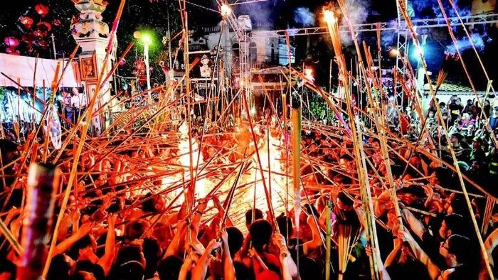 3. Ngọn lửa được duy trì bởi khối vàng mã lớn được xếp ở ngoài sân đình. Để tránh sức nóng, người dân sử dụng những thanh tre, nứa dài, đầu có gắn hương, để xin lửa