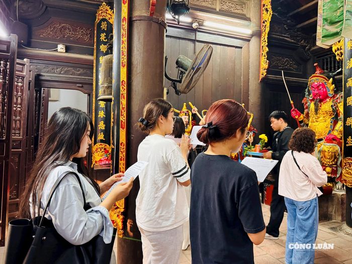 Nhóm bạn trẻ đang tỉ mỉ đọc văn khấn bằng cả tâm niệm và lòng thành của mình.