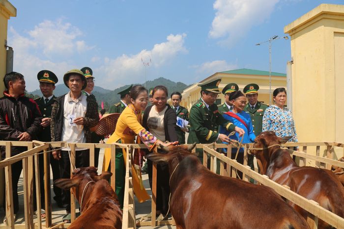 Thiếu tướng Vũ Quốc Ân và đồng chí Võ Thị Minh Sinh trao mô hình sinh kế cho người dân. Ảnh: Hải Thượng