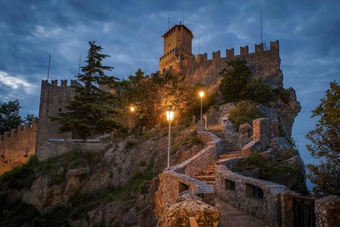Ngôn ngữ chính thức của San Marino là tiếng Italy. Quốc gia này sử dụng đồng euro mặc dù không phải là thành viên của Liên minh châu Âu. Cảnh quan San Marino chủ yếu được tạo nên bởi núi Titano - ngọn núi chiếm phần lớn diện tích quốc gia. Thủ đô nằm trên sườn núi, nổi bật với ba pháo đài thời trung cổ, vốn là những điểm tham quan chính của đất nước. Nền kinh tế San Marino chủ yếu dựa vào du lịch, mỗi năm thu hút hơn 3 triệu lượt du khách từ khắp nơi trên thế giới. Ảnh: Alexander Je Bradley.