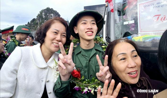 Tân binh chụp ảnh kỷ niệm cùng người thân trước giờ xe lăn bánh đưa các anh về đơn vị mới.